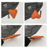 An orange heart-shaped PU coin purse with a leather wrist strap is shown against a gray jacket.