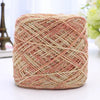 A ball of metallic silk crochet yarn with pink and gold shimmer threads for knitting and macrame.