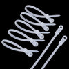 A collection of white reusable screw-hole cable ties with mounting holes arranged against a black background.