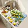 A lemon print absorbent kitchen drying mat featuring yellow lemons and green foliage placed on a light-colored countertop.