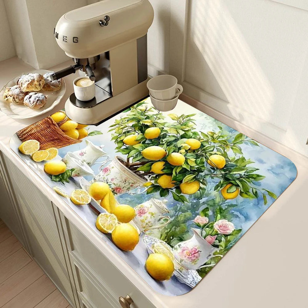 A lemon print absorbent kitchen drying mat featuring yellow lemons and green foliage placed on a light-colored countertop.