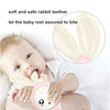 A baby is holding a pink rabbit teether toy, which is designed to let the baby rest assured to bite.