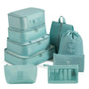 A set of light teal travel packing cubes and storage organizer bags stacked and displayed.
