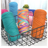 A collection of brightly colored thick yarn skeins in various shades including teal, purple, orange, and pink, displayed in a