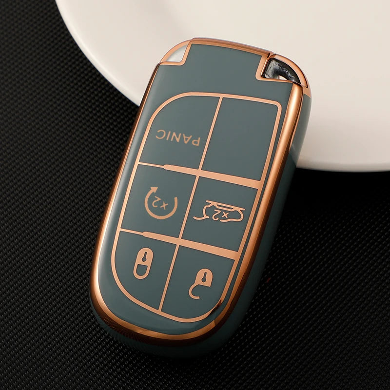 A close-up of a durable TPU car key case cover in a muted green color resting on a dark surface.