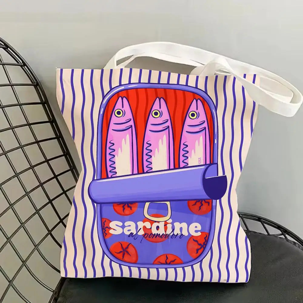 A canvas tote bag featuring a colorful print of sardines and a purple barrel design.