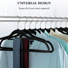 Black velvet non-slip hangers hanging clothes on a metal rod in a closet