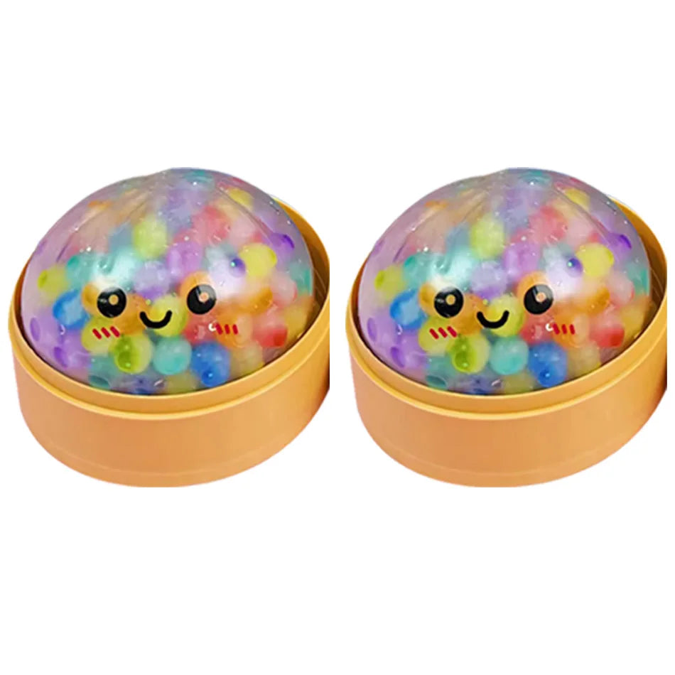 Ein Paar farbenfroher, durchscheinender Perlenknödel-Fidget-Spielzeuge in einem hellbraunen Behälter.