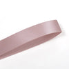 A roll of double face satin ribbon in a dusty rose color.