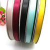A roll of double face satin ribbon in various solid colors, including pink, purple, black, teal, and yellow.