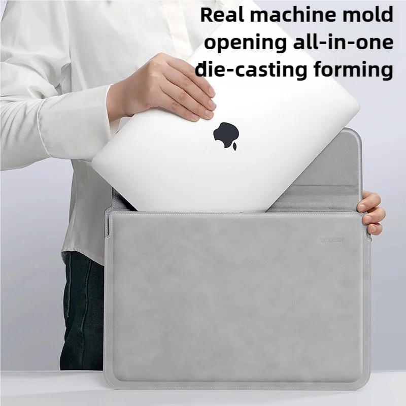 A hand places a white laptop into a gray protective sleeve case for die-casting forming.