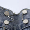 Silver metal button snaps attached to denim fabric for adjusting jeans