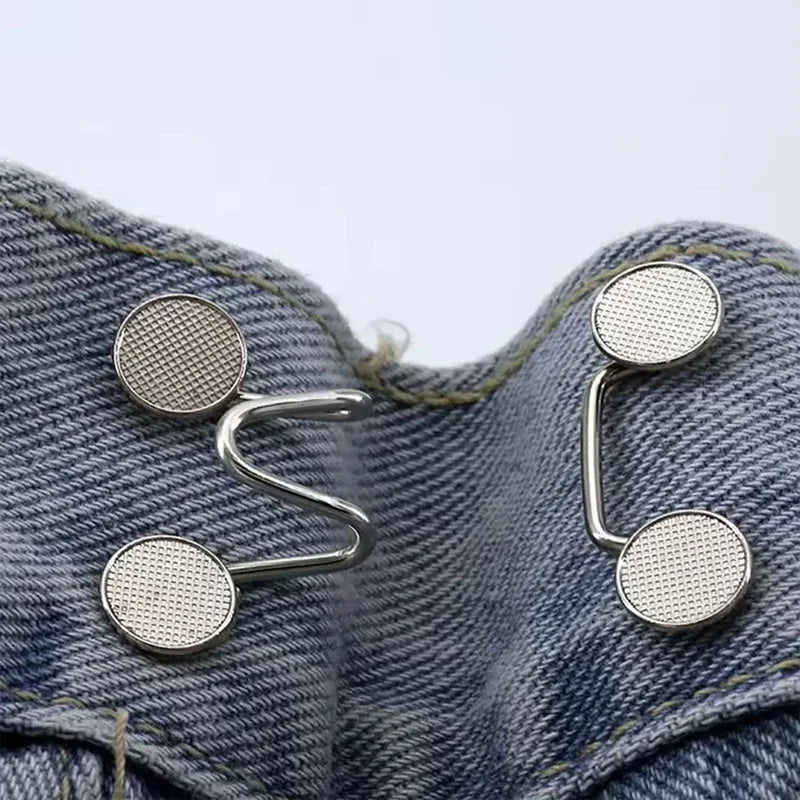 Silver metal button snaps attached to denim fabric for adjusting jeans
