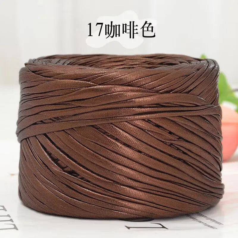 A spool of metallic brown flat ribbon yarn for crochet and knitting
