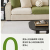 A beige sofa covered with a green jacquard fleece fabric and a cream cushion, displayed in a living room setting.