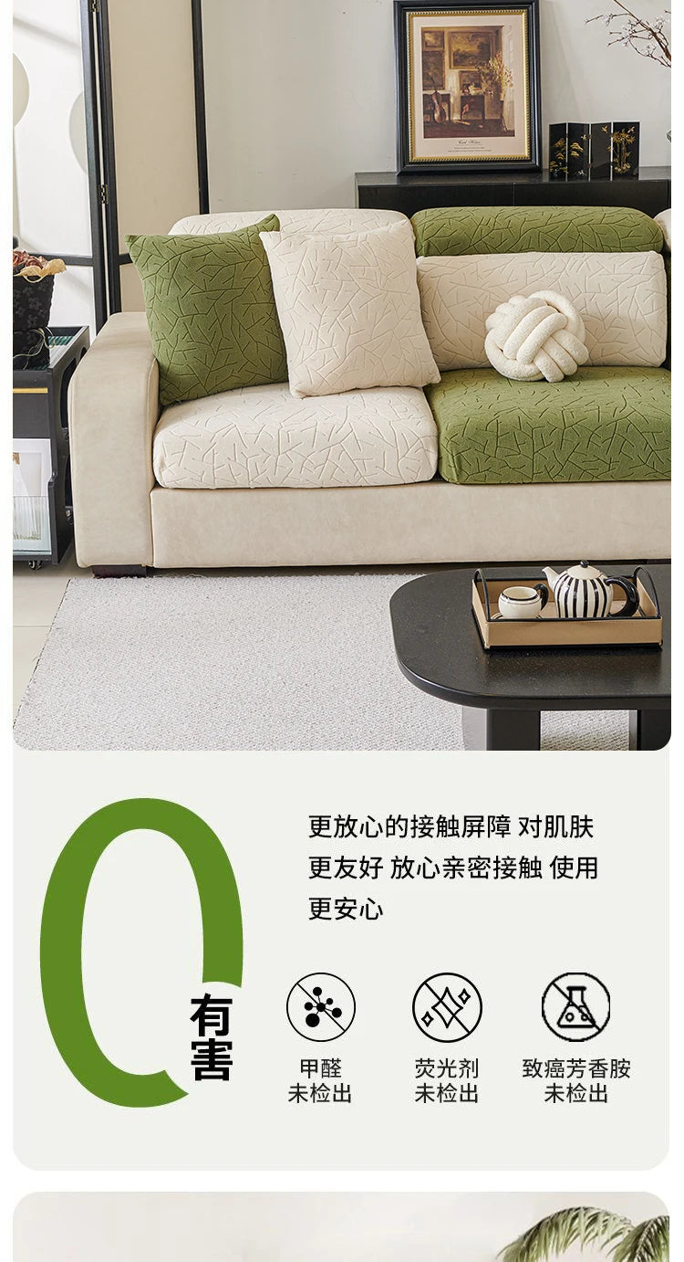 A beige sofa covered with a green jacquard fleece fabric and a cream cushion, displayed in a living room setting.