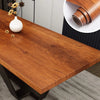 A close-up view of a wooden table with a roll of wood grain wallpaper film on a white plate.