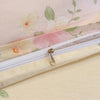 A close-up of a light pink floral printed duvet cover set with a zipper detail.