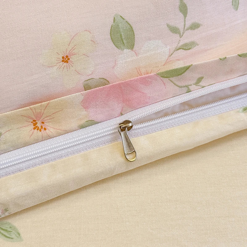 A close-up of a light pink floral printed duvet cover set with a zipper detail.