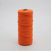 A spool of bright orange macrame cord used for crafting.