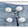 A close-up of a denim garment featuring silver-toned buttons used as an adjustable waist tightener.