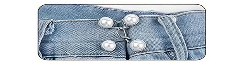 A close-up of a denim garment featuring silver-toned buttons used as an adjustable waist tightener.