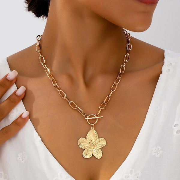Goldkette mit Vintage-Wisteria-Blüten-Anhänger um den Hals getragen.