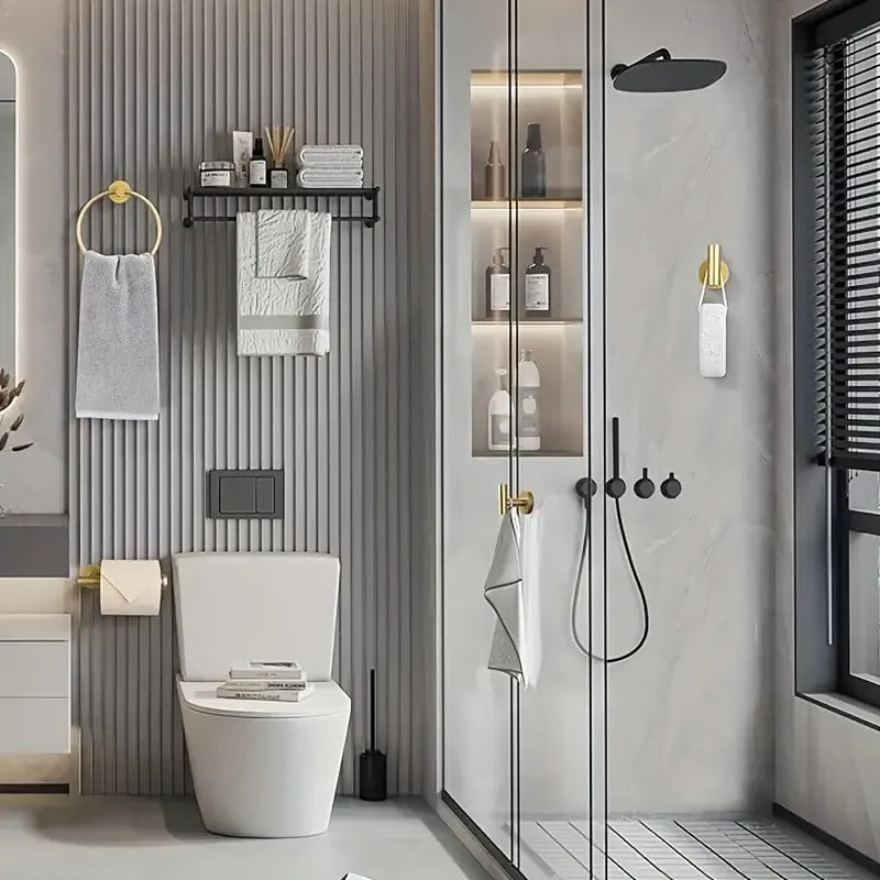 A modern bathroom featuring a toilet, wall-mounted towel hooks, and a glass shower enclosure with stainless steel accessories