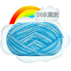 A ball of light blue and white milk cotton blend yarn is shown against a background featuring a rainbow and a white cloud.