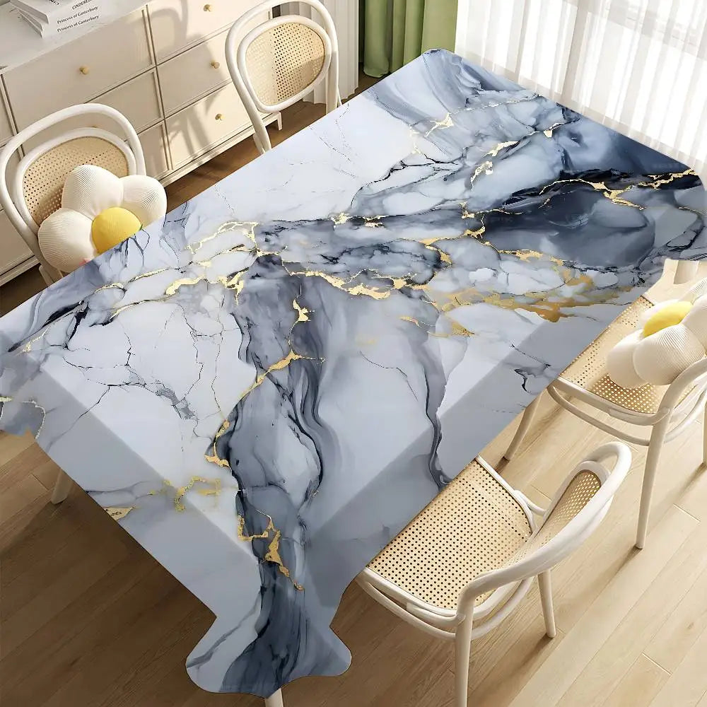 A marble tablecloth featuring blue and white veining with gold accents on a wooden table in a bright room.
