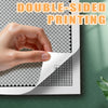 A hand is demonstrating double-sided printing on a sheet of paper featuring a black and white pixel mosaic pattern.
