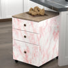 A white dresser with pink marble finish and a dark countertop displaying decorative spheres.