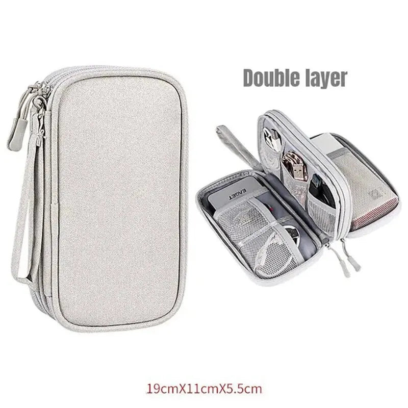 A silver double-layer travel organizer pouch for cables and accessories.