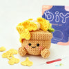 A finished crocheted cute animal or plant project made from light brown yarn, displayed next to loose yarn and a crochet need