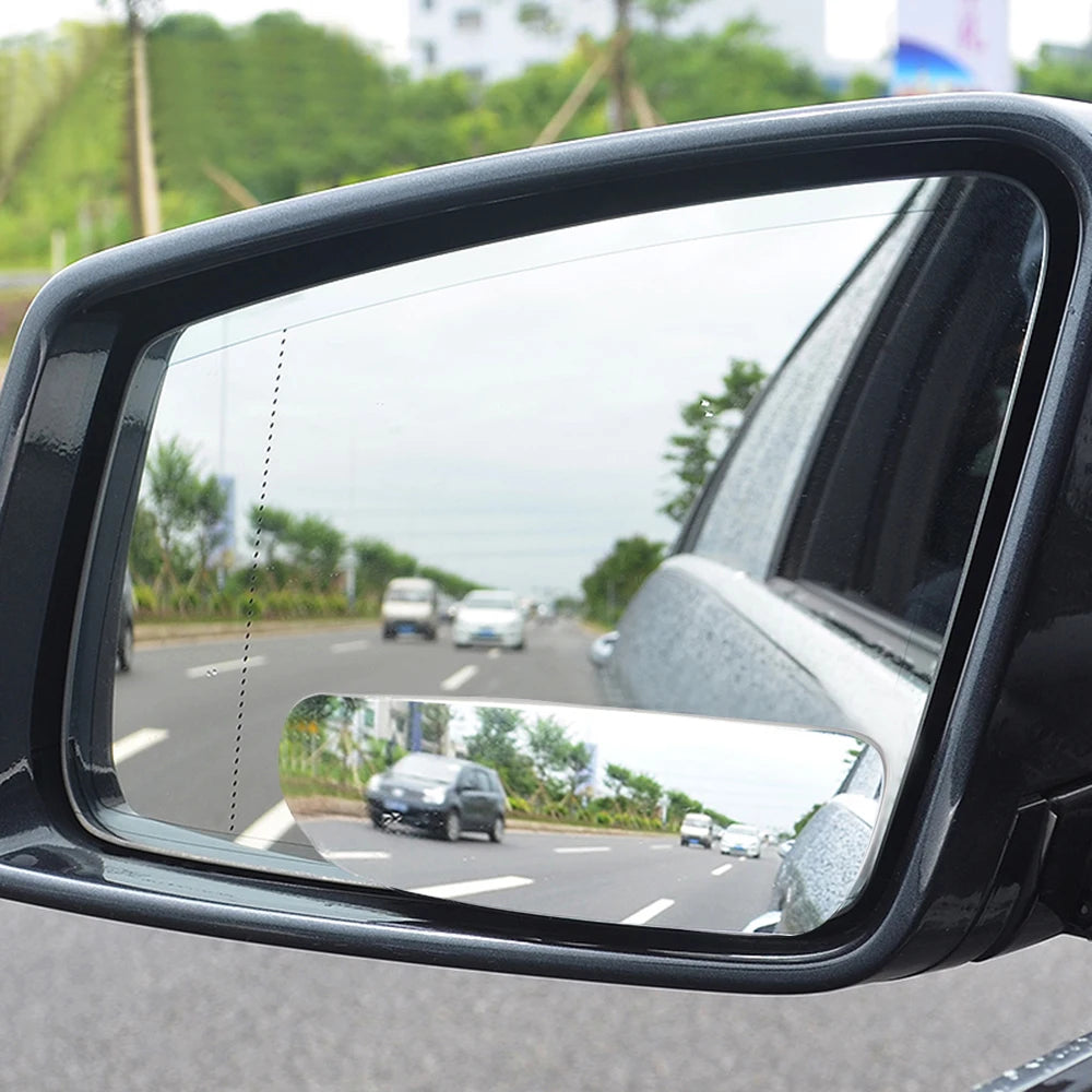A close-up view of a black 360° wide angle blind spot mirror mounted on a vehicle.