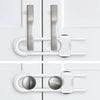 Close-up of adjustable U-shaped child safety cabinet locks with knob handles in silver and white.