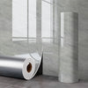 A roll of self-adhesive marble wall sticker for kitchen and bathroom displayed next to a gray marble wall.