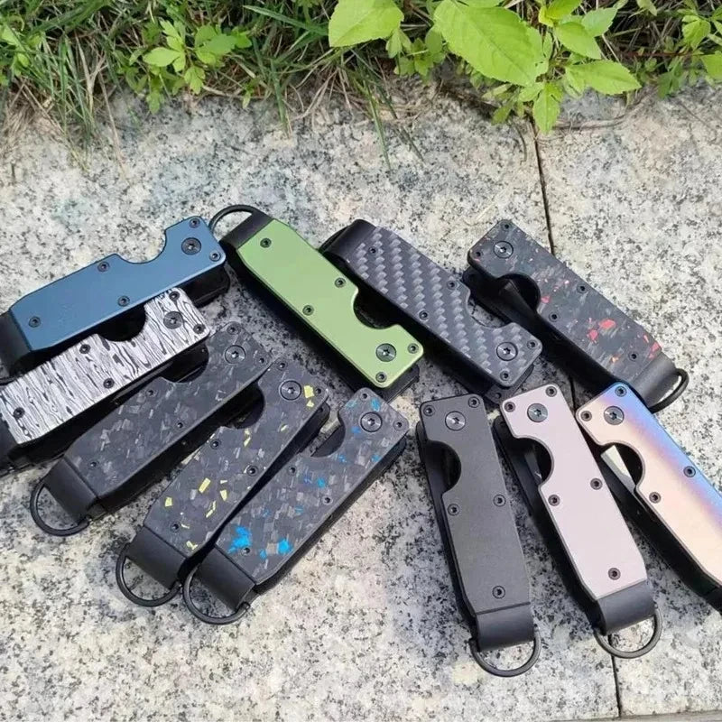 A collection of minimalist aluminum key organizers in various black, green, and silver finishes resting on a light stone surf