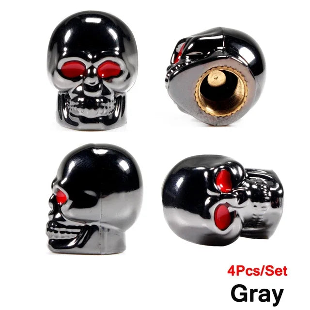 A set of four gray skull design tire valve stem caps with red accents.