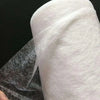 Roll of white double-sided iron-on adhesive tape used for fabric hemming and repairs