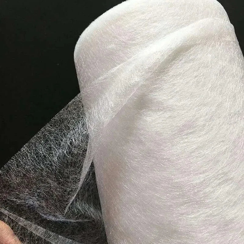 Roll of white double-sided iron-on adhesive tape used for fabric hemming and repairs