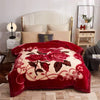 A deep red weighted plush blanket featuring a large floral pattern on a white background.