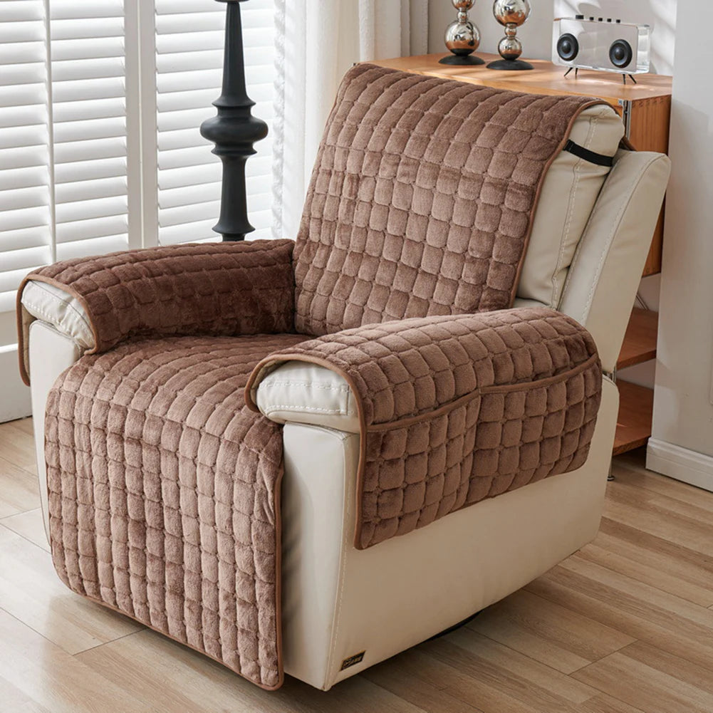 A beige quilted stretch recliner cover with brown fabric and storage pockets sitting on a wooden shelf.