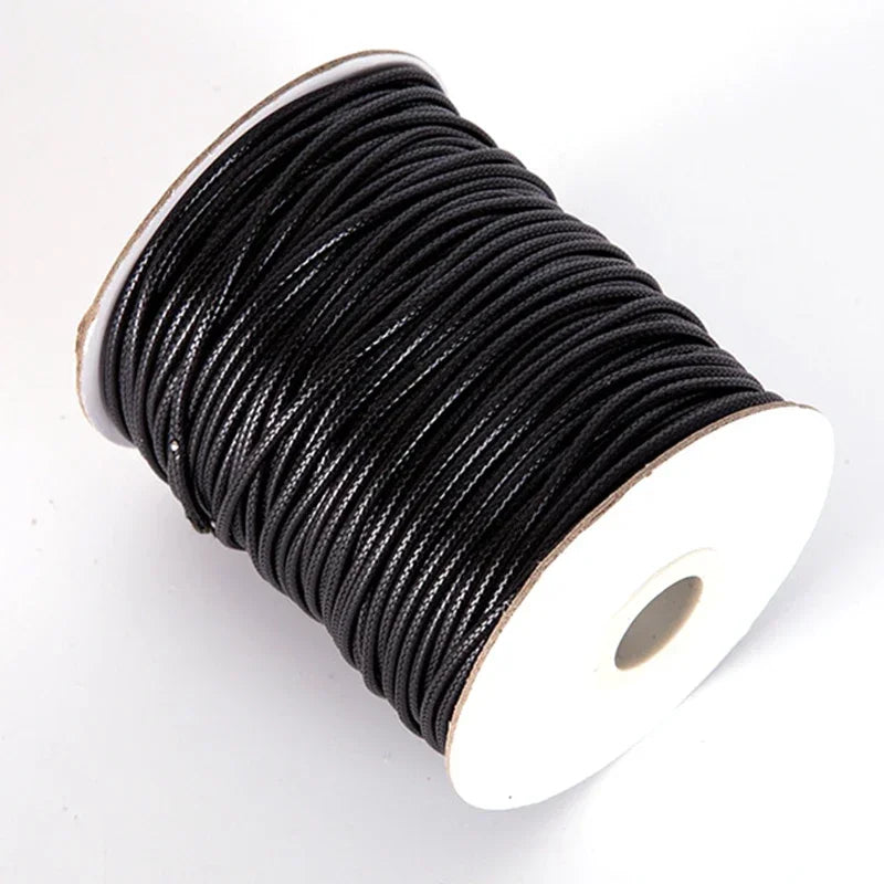 A spool of black waxed cord rope used for jewelry making and DIY projects.