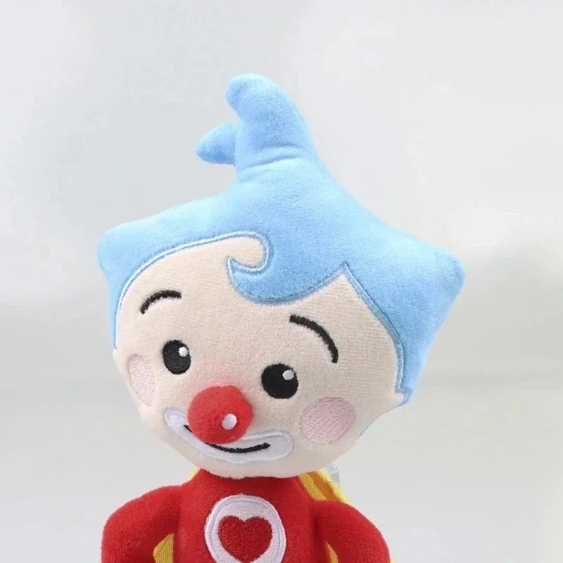 A soft blue and red plush toy of a clown with a spiky hairstyle.