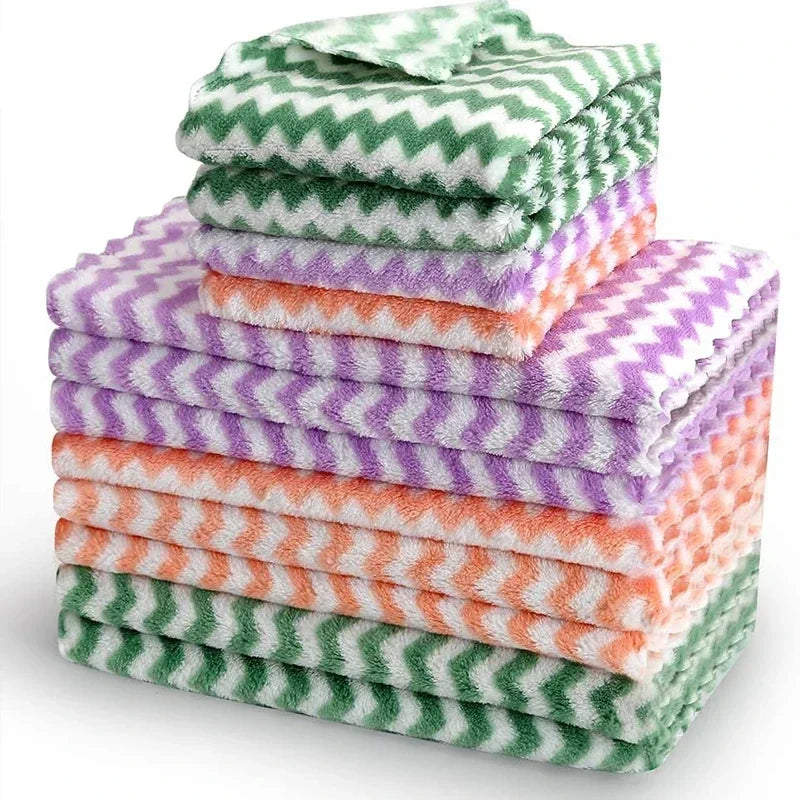 Ein Stapel verdickter Samtputz-Tücher in verschiedenen Grüntönen, Violett und Orange.