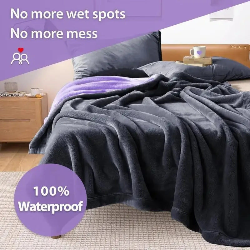 A dark gray waterproof flannel blanket draped over a bed, with text emphasizing no wet spots and mess.