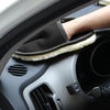 A hand wearing black microfiber car wash gloves rests on a car interior panel.