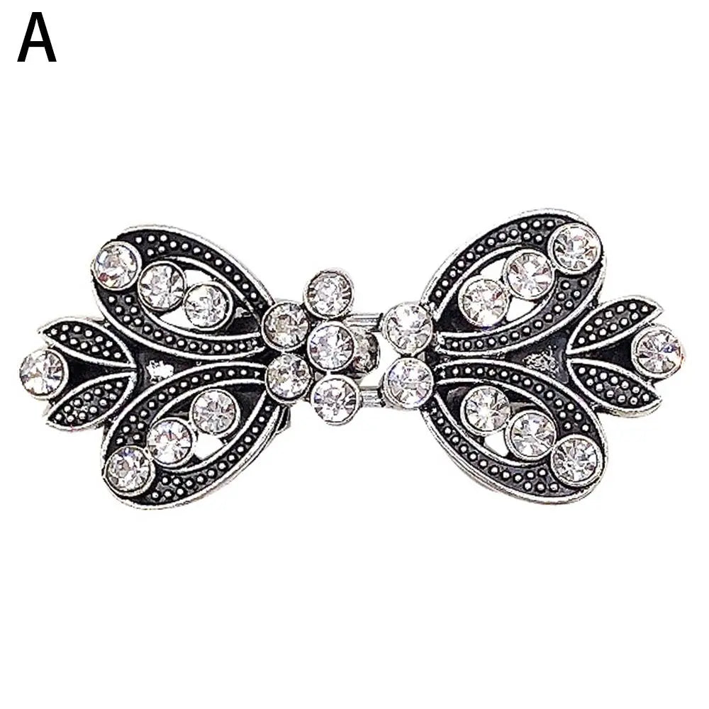 Vintage silver swirl clip featuring clear rhinestones used to fasten cardigans and shawls