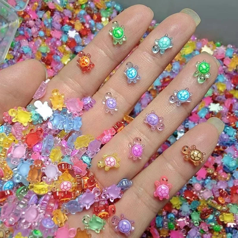 A hand holds a large collection of glow-in-the-dark mini turtle figurines in various bright colors.